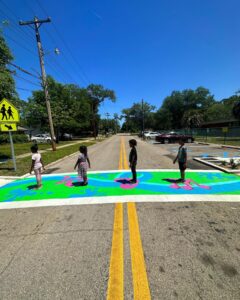 Four students crossing painted crosswalk